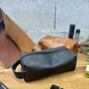 Gros plan sur une trousse de toilette en cuir noir artisanale réalisée lors d'un atelier créatif près de Toulouse