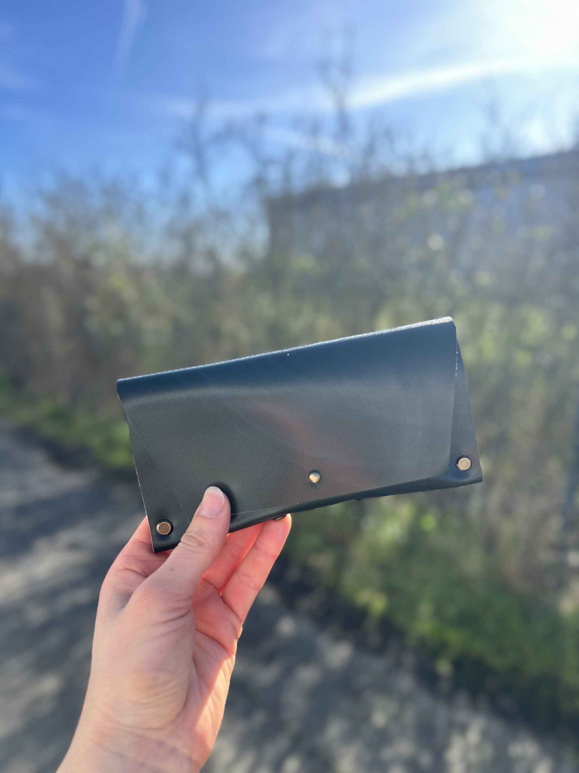atelier-etui-lunettes-cuir-vert-toulouse tui à lunettes en cuir vert fermé avec rivets, fabriqué à la main lors d'un atelier maroquinerie à Tournefeuille