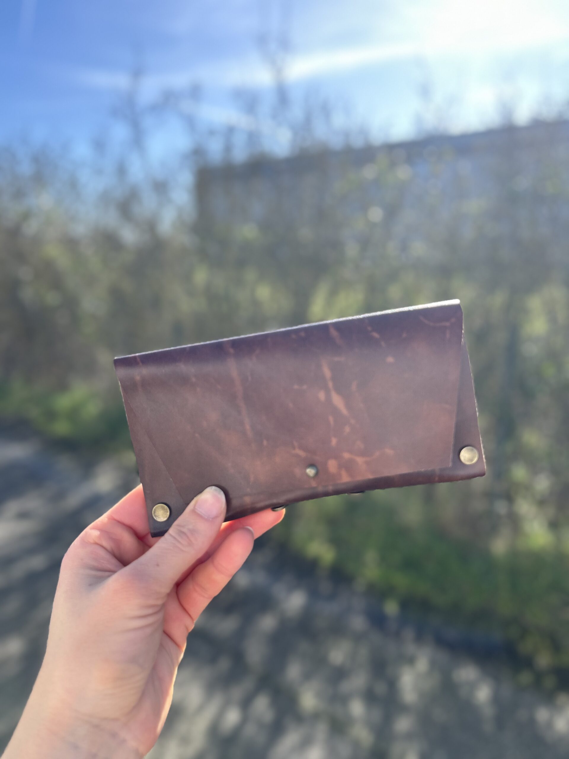 atelier-etui-lunettes-cuir-brun-tournefeuille Étui à lunettes en cuir brun foncé fermé avec rivets dorés, fabriqué à la main lors d'un atelier cuir à Tournefeuille